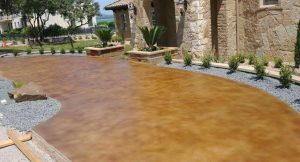 A stained concrete patio has been transformed into a beautiful outdoor living space, perfect for entertaining and relaxing.